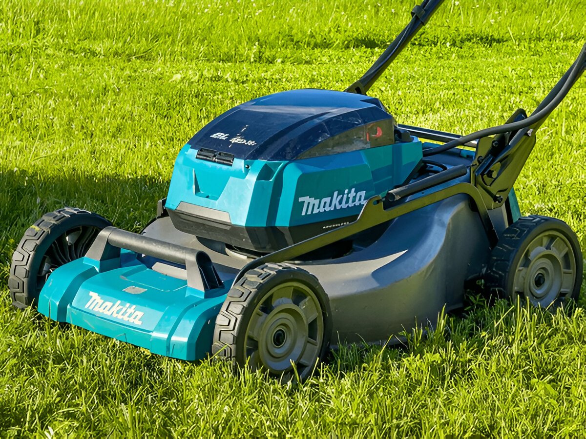 EGO, STIHL, and Makita cordless garden tools lined up on grass, ready for use in professional landscaping